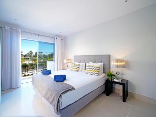 een slaapkamer met een groot bed en een groot raam bij Apartment Pine Hills Esmeralda by Interhome in Vilamoura