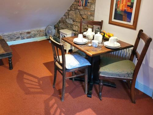 mesa de comedor con sillas y mesa con tazas en Ballyrider House Beautiful Triple Suite, en Inch Cross Roads