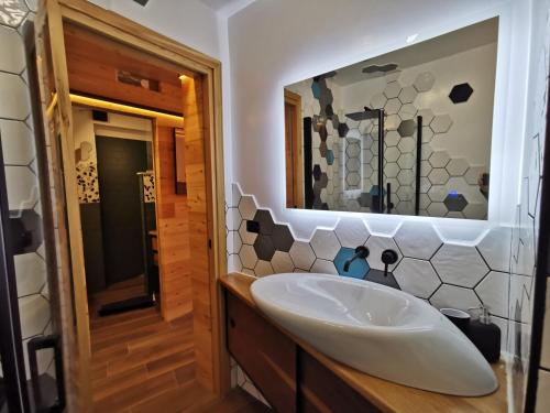 a bathroom with a sink and a mirror at Hostdomus - Oslo Apartments in Borgata Sestriere