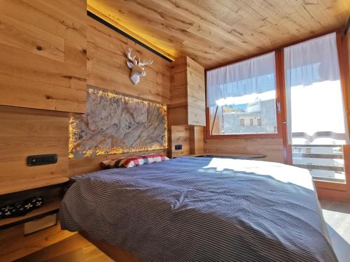 a bedroom with a bed in a wooden cabin at Hostdomus - Oslo Apartments in Borgata Sestriere