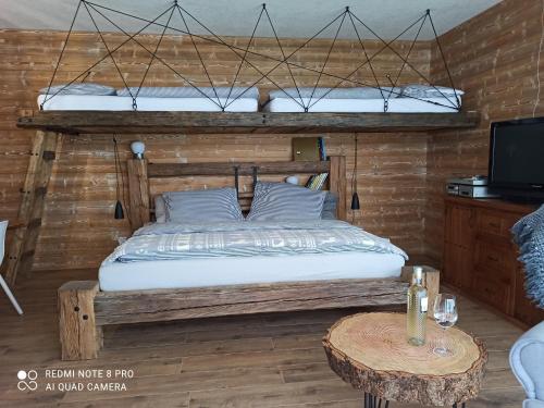 1 dormitorio con 1 cama y pared de madera en Chata pod smrekmi, en Hriňová