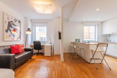 a living room with a couch and a kitchen at Portas Do Bairro in Lisbon