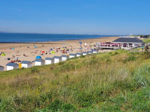 Plaża z grupą ludzi na niej w obiekcie Le Normandy 5star w mieście Cadzand