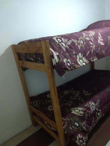 Litera de madera en habitación con manta morada en Duplex San Rafael Mendoza en San Rafael