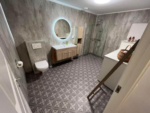 a bathroom with a toilet and a sink and a mirror at Tromsø stunning Luxury apart A in Larseng