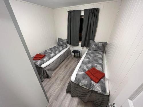 a small room with two beds and a window at Tromsø stunning Luxury apart A in Larseng