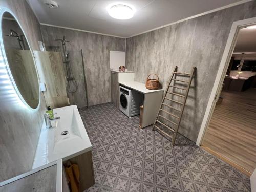 a bathroom with a sink and a washing machine at Tromsø stunning Luxury apart A in Larseng