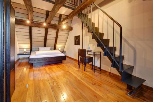 ein Schlafzimmer mit einem Bett und einer Treppe in der Unterkunft Landgasthof am Königsweg in Ohmden
