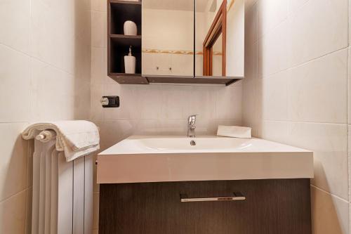 a bathroom with a white sink and a cabinet at Modern Lakefront 1-Bedroom Apartment in Acquaseria