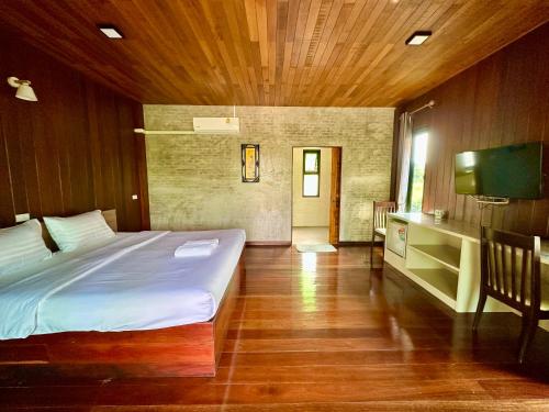 a bedroom with a bed and a television in it at เพชรพิชชารีสอร์ท in Ban Bang Kham