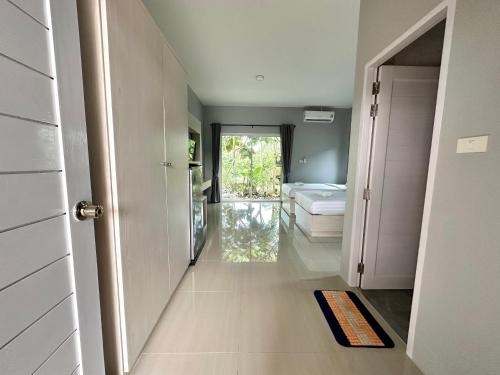 pasillo con habitación con cama y puerta en เพชรพิชชารีสอร์ท, en Ban Bang Kham