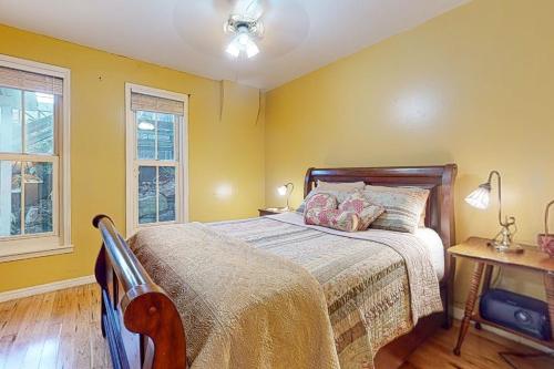a bedroom with yellow walls and a bed and a table at Harken Lodge in Eureka Springs
