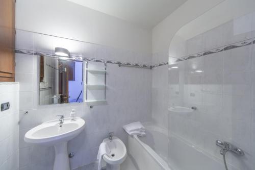 a white bathroom with a sink and a toilet at Studio Apartment Lake Views in Acquaseria