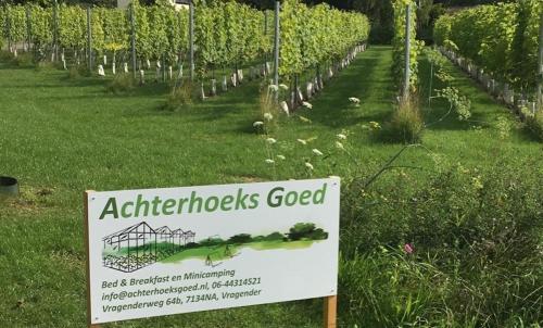 a sign in a field with a garden at Achterhoeks Goed, Minicamping in Vragender in Vragender
