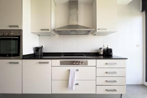 a kitchen with white cabinets and a stove top oven at chicStays Apartment Ciutadella Park in Barcelona