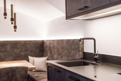 uma cozinha com um lavatório e uma bancada em ROUDA luxury retreat am Kronplatz em Valdaora