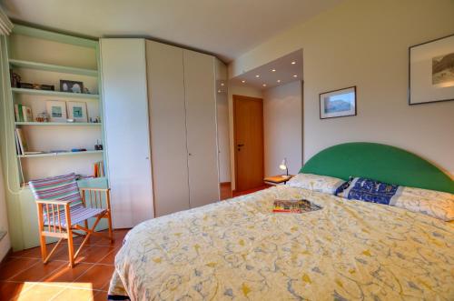 Schlafzimmer mit einem großen Bett mit einem grünen Kopfteil in der Unterkunft 2-Bedroom Lakeview Apartment Bella Gaeta in San Siro
