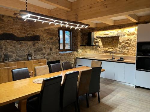 een keuken en eetkamer met een houten tafel en stoelen bij Casas rurales Villa la Roza in La Utrera