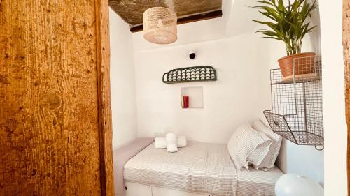 mały pokój z łóżkiem i rośliną w obiekcie Th_eros House w mieście Istérnia