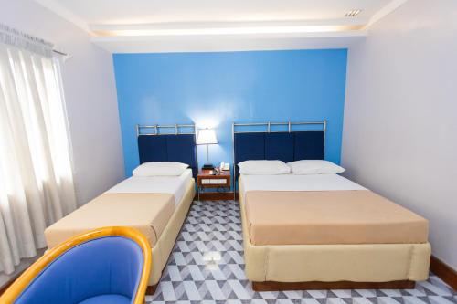 two beds in a room with blue walls at Hotel Valencia in Valencia