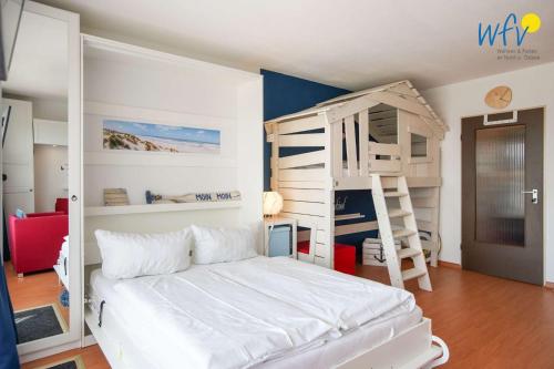 a bedroom with a white bed and bunk beds at Holiday Residenz - Ferienwohnung "Kuestenkind" in Borkum