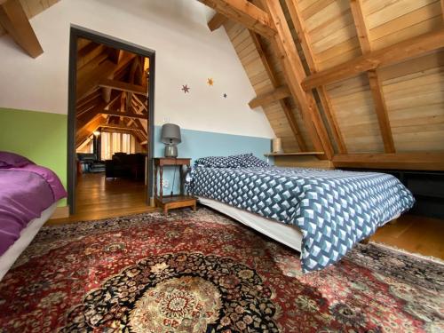 een slaapkamer met een bed en een tapijt bij La Grange d'Emmanuel, Marsous, 6-8 pers in Arrens-Marsous