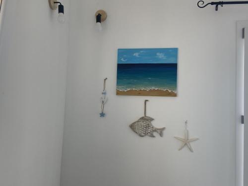 a wall with a picture of the beach and a starfish at Li sireni LA FRISAIA Bilocale vista mare FP7 Trinità d'Agultu e Vignola in Cascabraga