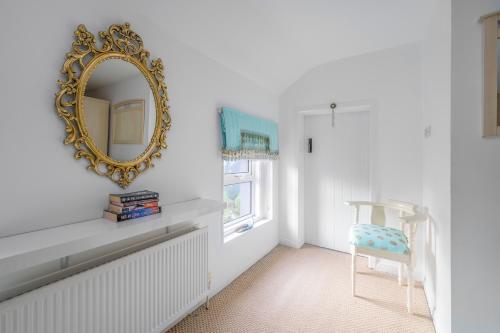 a mirror and a chair in a white room at Willow House Bed & Breakfast and Orchard Studios Self Catering in Limavady