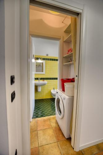 a bathroom with a washing machine and a sink at Bello Pianello Lake View Apartment in Pianello Del Lario