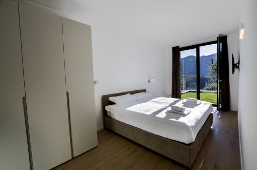 1 dormitorio con cama y ventana grande en Casa Antonia 2-Bedroom Deluxe Lake View Apartment, en Lenno