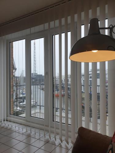 a room with windows with a view of a city at Marina View in Cuxhaven
