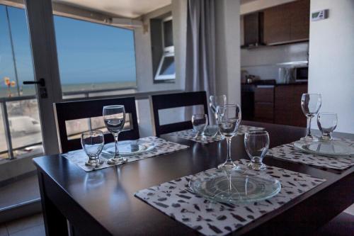 una mesa con copas de vino encima en Un ambiente frente al mar en Mar del Plata
