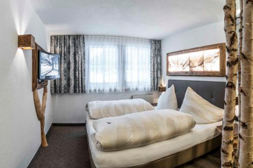 a hotel room with a bed and a couch at Almhof-Reithof Pitztal in Sankt Leonhard im Pitztal