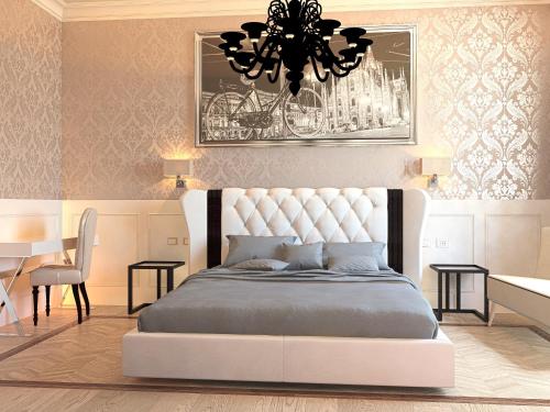 a bedroom with a large bed and a chandelier at Duomo Rooms in Milan