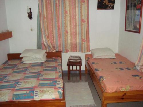 Cette chambre comprend 2 lits, une table et une fenêtre. dans l'établissement Souriam Villa, à Grand Baie