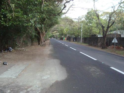 an empty road with trees on the side of the road at Souriam Villa in Grand-Baie