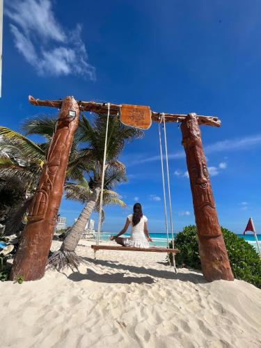 a woman sitting on a swing on the beach at Ocean Seaview Dream condo next to clubs in Cancún