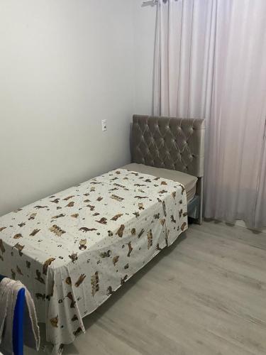 a bedroom with a bed with a comforter on it at Casa Temporada in Camboriú