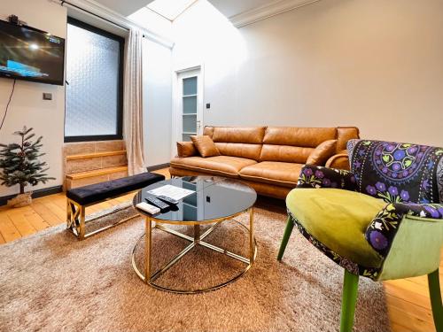 uma sala de estar com um sofá e uma mesa em Апартаменти Стефани em Plovdiv