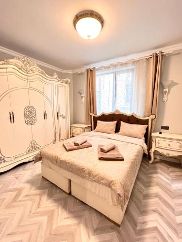 a bedroom with a large bed with two towels on it at Апартаменти Стефани in Plovdiv
