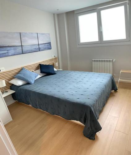 a bedroom with a large bed with blue pillows at El Solarón in Gijón