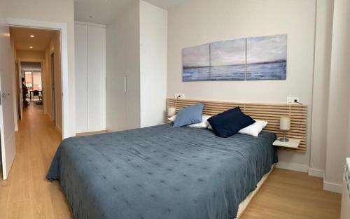 - une chambre dotée d'un grand lit avec des draps bleus dans l'établissement APARTAMENTO EL SOLARON, à Gijón