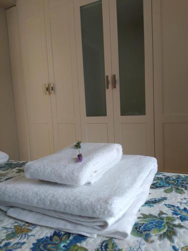 una pila de toallas sentadas encima de una cama en Casa de piedra acogedora a 2 minutos de la playa en Laxe