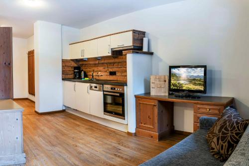 a kitchen with a desk with a television on it at Almhof-Reithof Pitztal in Sankt Leonhard im Pitztal
