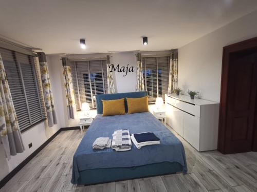Un dormitorio con una cama azul con dos toallas encima. en Słoneczne Apartamenty, en Sokołowsko