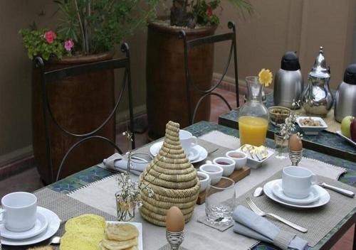 a table with a breakfast of eggs and food at Riad Dar Teranga Hotel & Spa in Marrakech