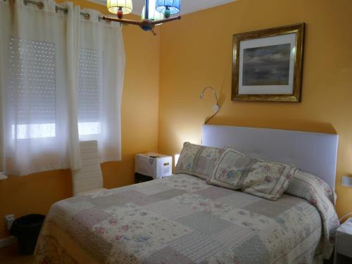 a bedroom with a bed and a picture on the wall at Habitaciones en Aviles in Avilés