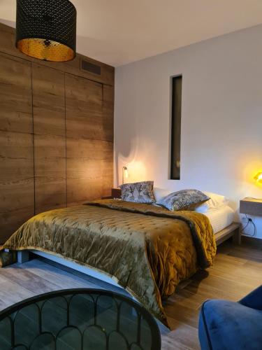 une chambre avec un grand lit avec un mur en bois dans l'établissement Domaine Villa ELEA, à Nice