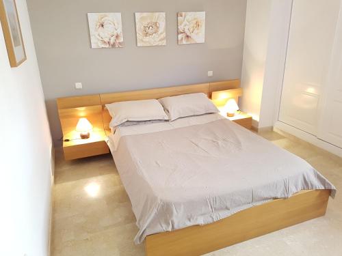 1 dormitorio con 1 cama grande y 2 mesitas de noche en Apartamento Pelicanos Golf & Beach - spacious and modern with terrace and private pool, en Roquetas de Mar