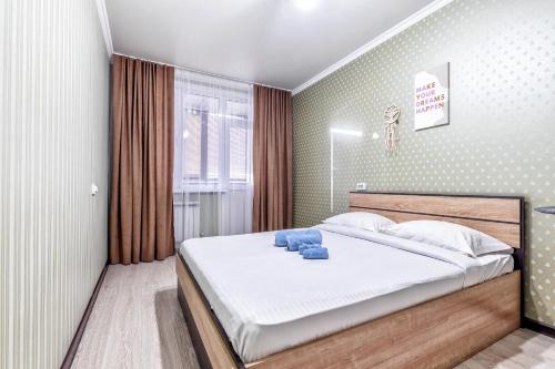 Un dormitorio con una cama con toallas azules. en Edem Palas 2, en Astana